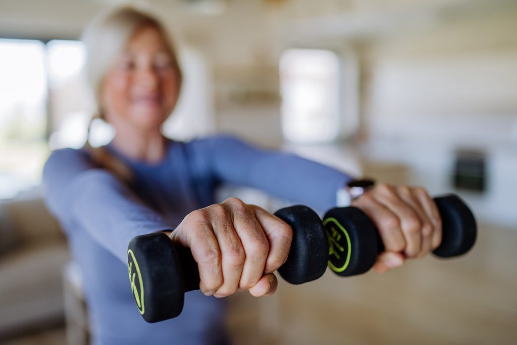 Keep Fit With Paula Hazel Grove - fit senior woman exercising with dumbbells at home 1